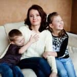 Mamma single: madre con due bambini in un momento quotidiano familiare