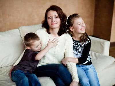 Mamma single: madre con due bambini in un momento quotidiano familiare