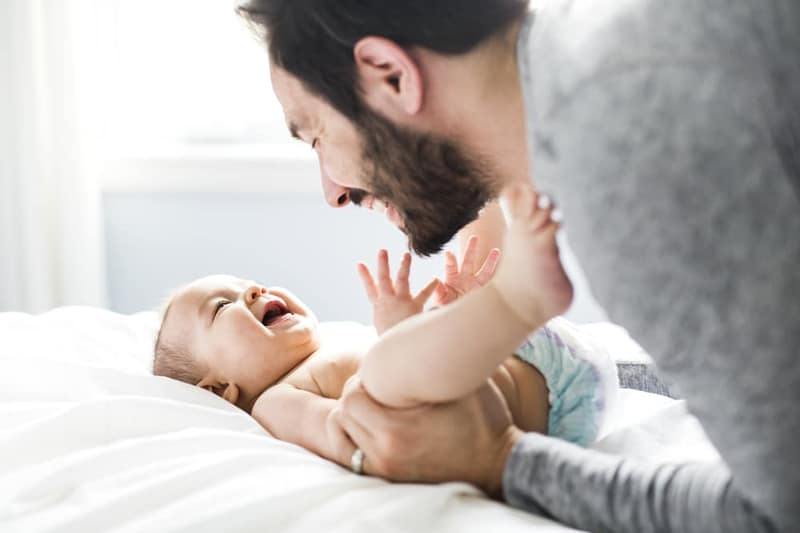 felice padre che gioca adorabile bambino camera da letto