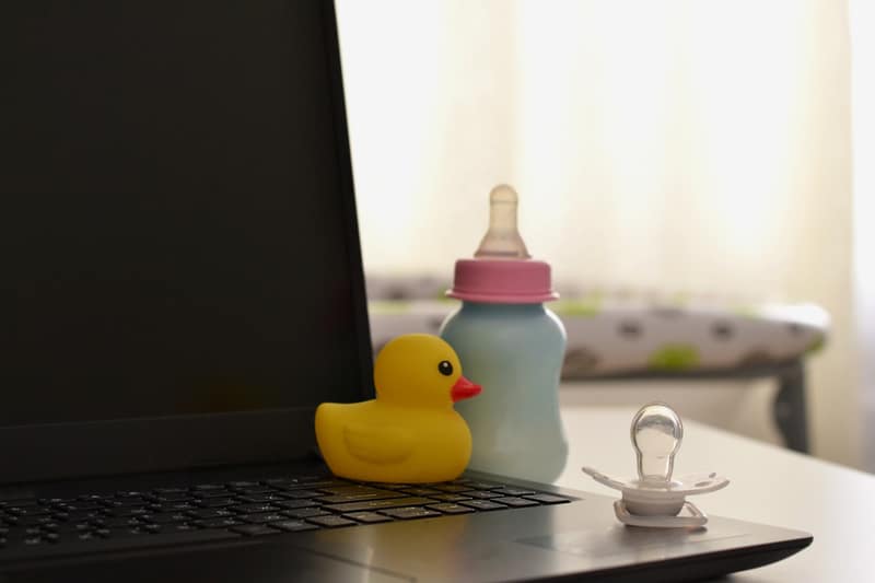 laptop e biberon. Concetto di congedo di maternità.